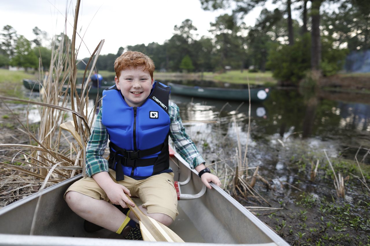 Paddling a canoe on a calm lake.