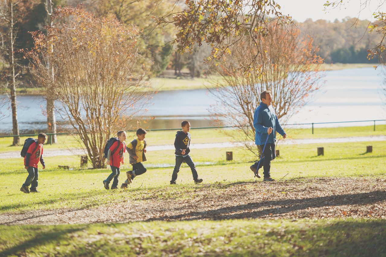 Cubs hiking along a fall lakeside trail.