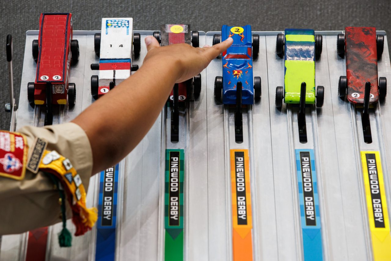 Pinewood Derby cars line up at the start.